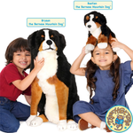 Two children with a large stuffed Bernese Mountain Dog toy and a smaller Bernese Mountain Dog plush toy on a white background.