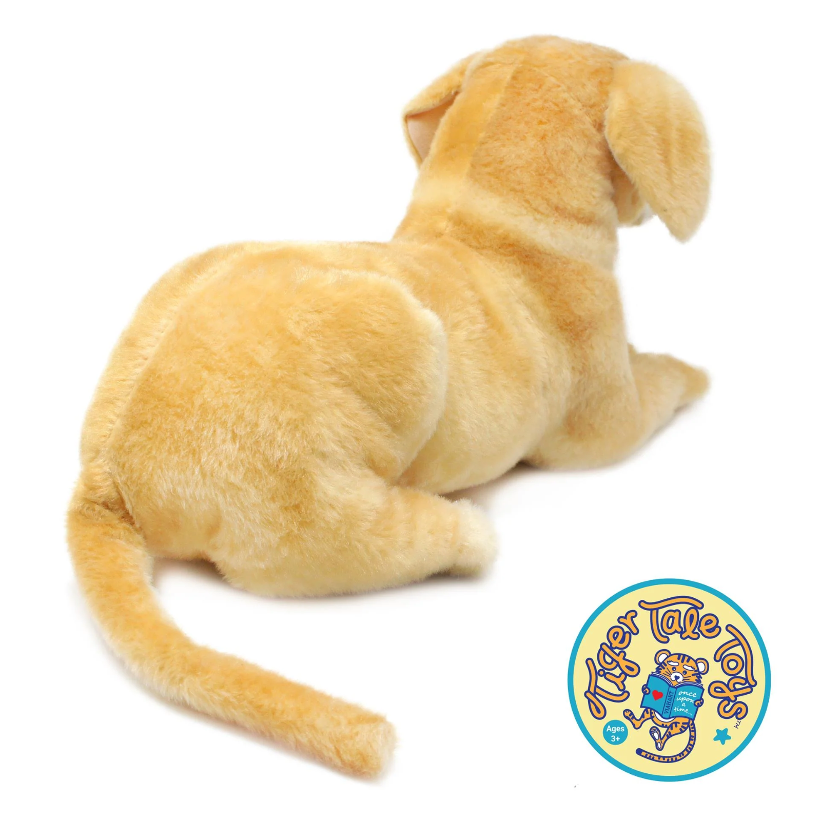 A golden yellow plush puppy toy shown from the back on a white background, with a circular 'Tiger Tale Toy' logo in the bottom right corner.