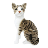 A realistic cat-shaped plush toy or stuffed animal sitting upright on a plain white background. The toy has brown and black tabby stripes, a white chest and paws, and a small orange-brown nose.