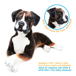 Boxer plush dog toy lying down on a white background, with a circular inset showing the foam head detail and text noting safety standards and USA/made-in-China claims.