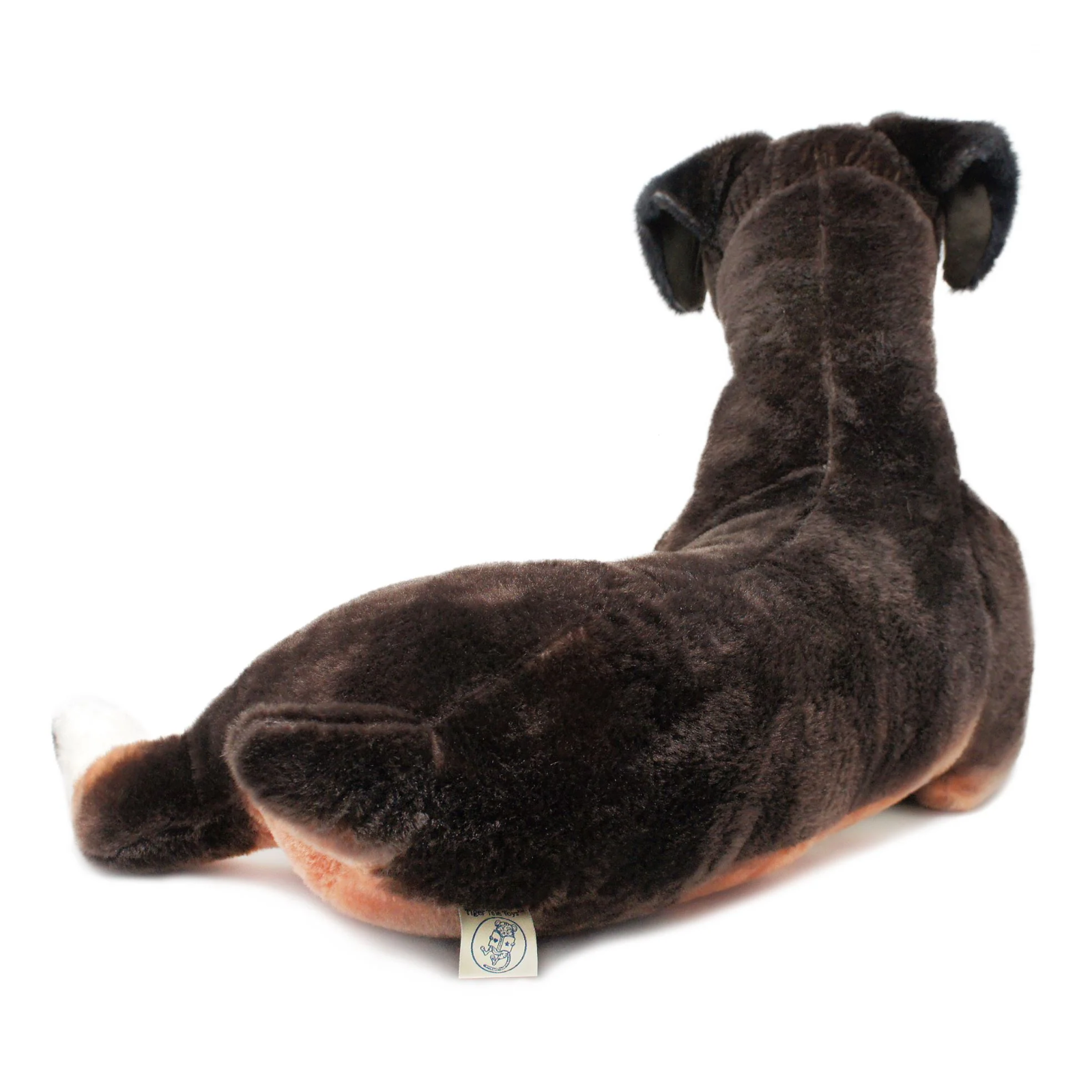 A dark brown plush dog toy shown from the back on a clean white background, featuring a small fabric tag near the base.