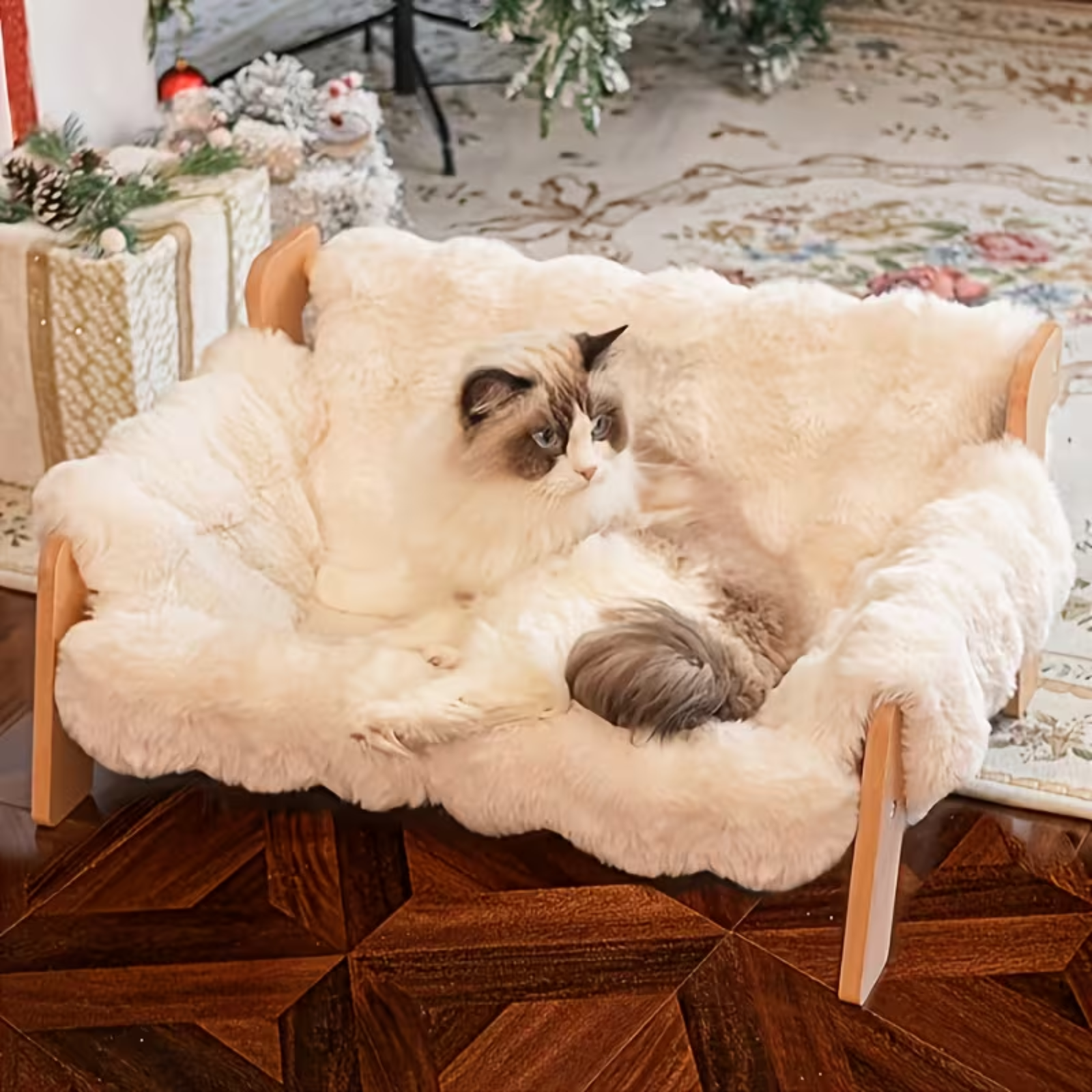 Cat lounging on a fluffy white pet bed in a cozy room with Christmas decorations.