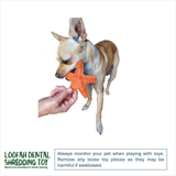 A small tan and white dog stands on a white background while a human hand holds an orange star-shaped toy near its mouth. A green and black 'Loofah Dental Shredding Toy' logo appears in the lower left, with a warning text box at the bottom right.