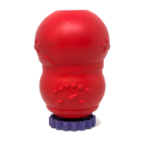 A red silicone dog toy with textured bumps, standing on a purple fluted base against a white background.