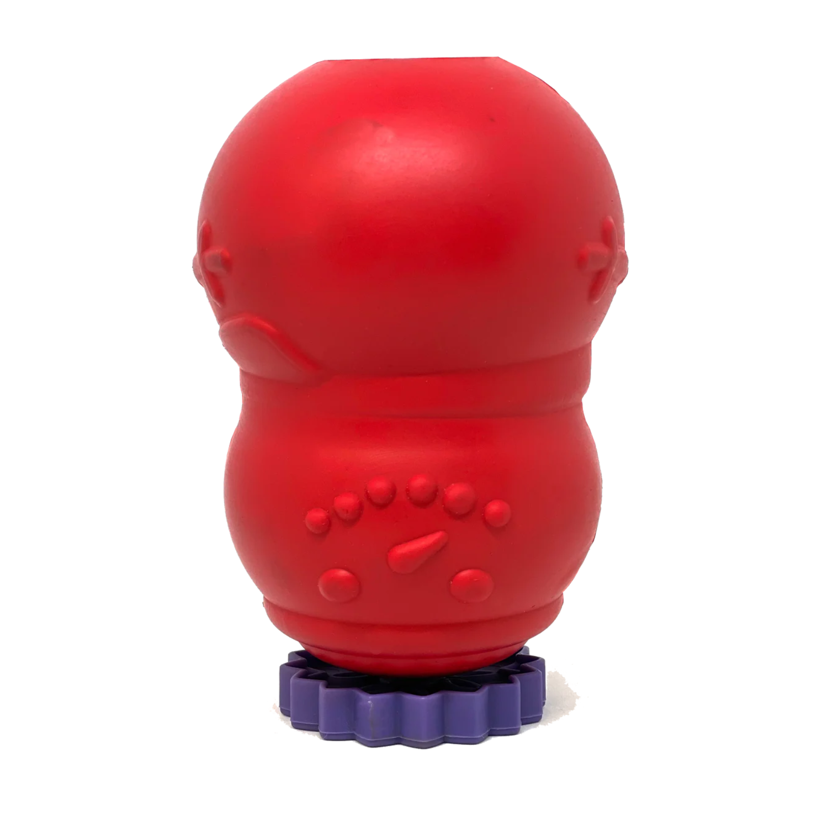 A red silicone dog toy with textured bumps, standing on a purple fluted base against a white background.