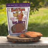 Package of Sam's Yams Big Boyz sweet potato dog treats on a wooden stand with a natural background.