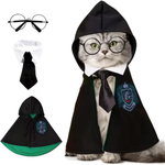 A cat wearing a black wizard-style costume cape with a white collar, black tie, and green crest patch, shown on a white background. The image also includes separate views of the costume pieces: round wire glasses, the white collar, the black tie, and the cape with green lining and crest.