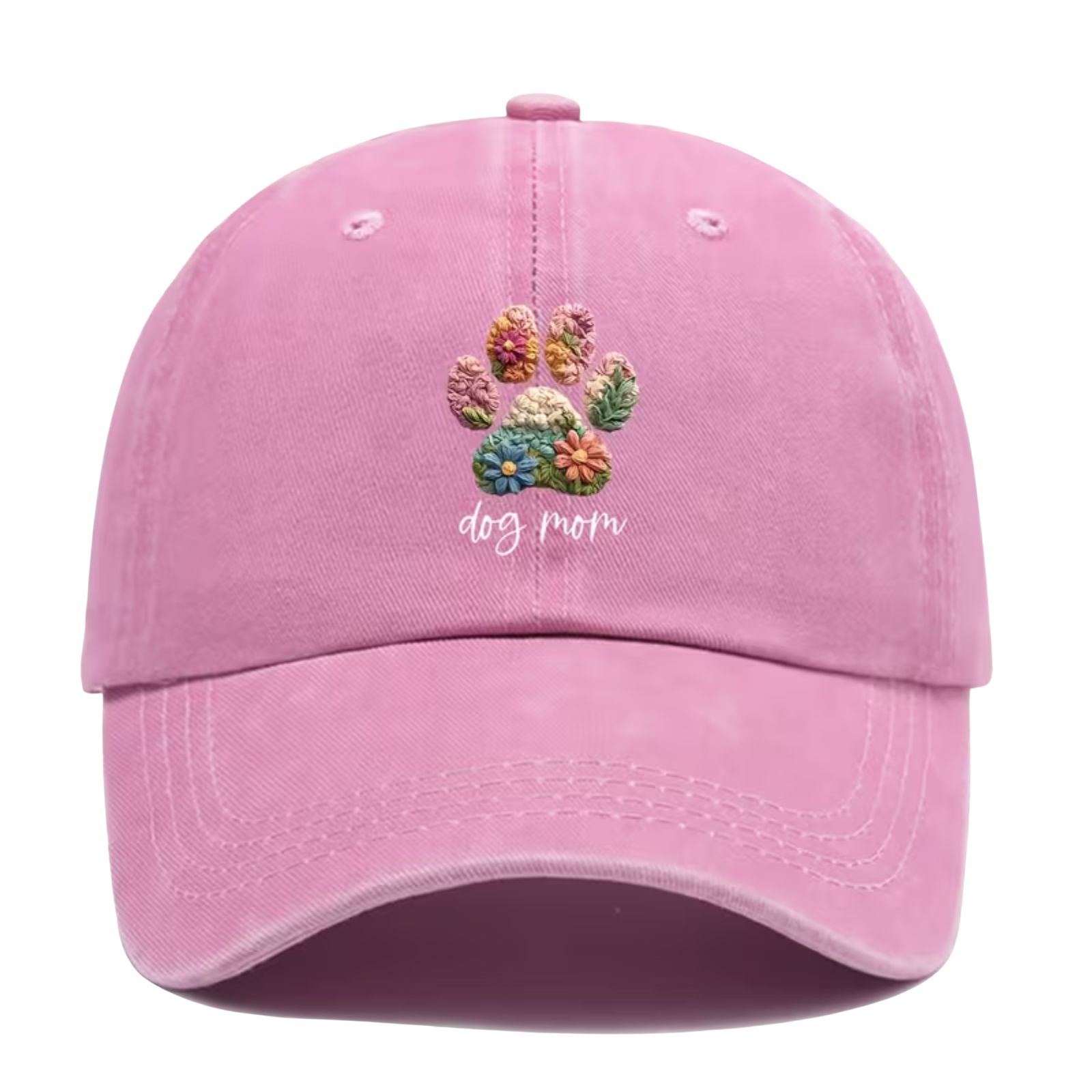 A light pink baseball cap featuring a colorful embroidery-style dog paw print with flowers and the words 'dog mom' in white script on the front. 