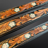 Decorative leather straps with floral patterns on a dark background