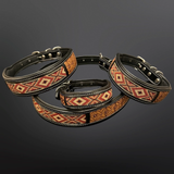 Three black leather dog collars with geometric patterned bands in red, orange, and beige, arranged on a dark gray gradient background.