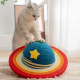 Grey and white cat playing with a colorful planet-shaped textured cat scratcher.