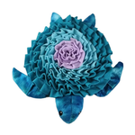 Plush blue and purple turtle shaped toy on a white background.