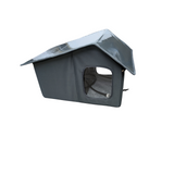 A grey fabric dog or cat house with a cord on the inside pictured at an angle to show a shiny plastic roof