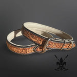 Brown leather dog collar with intricate patterns on a dark background