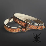 Brown leather dog collar with intricate patterns on a dark background